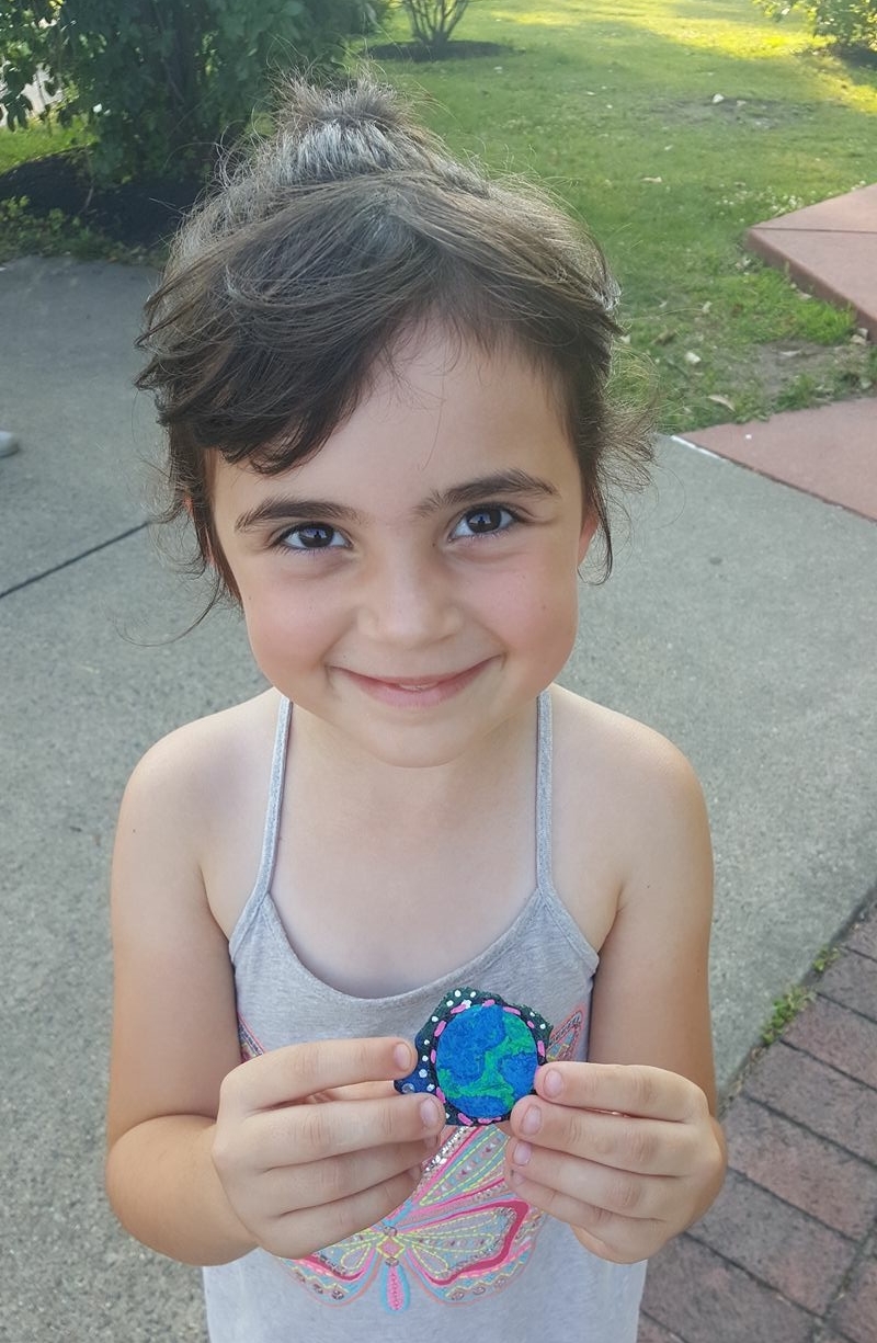 Child with blue painted rock