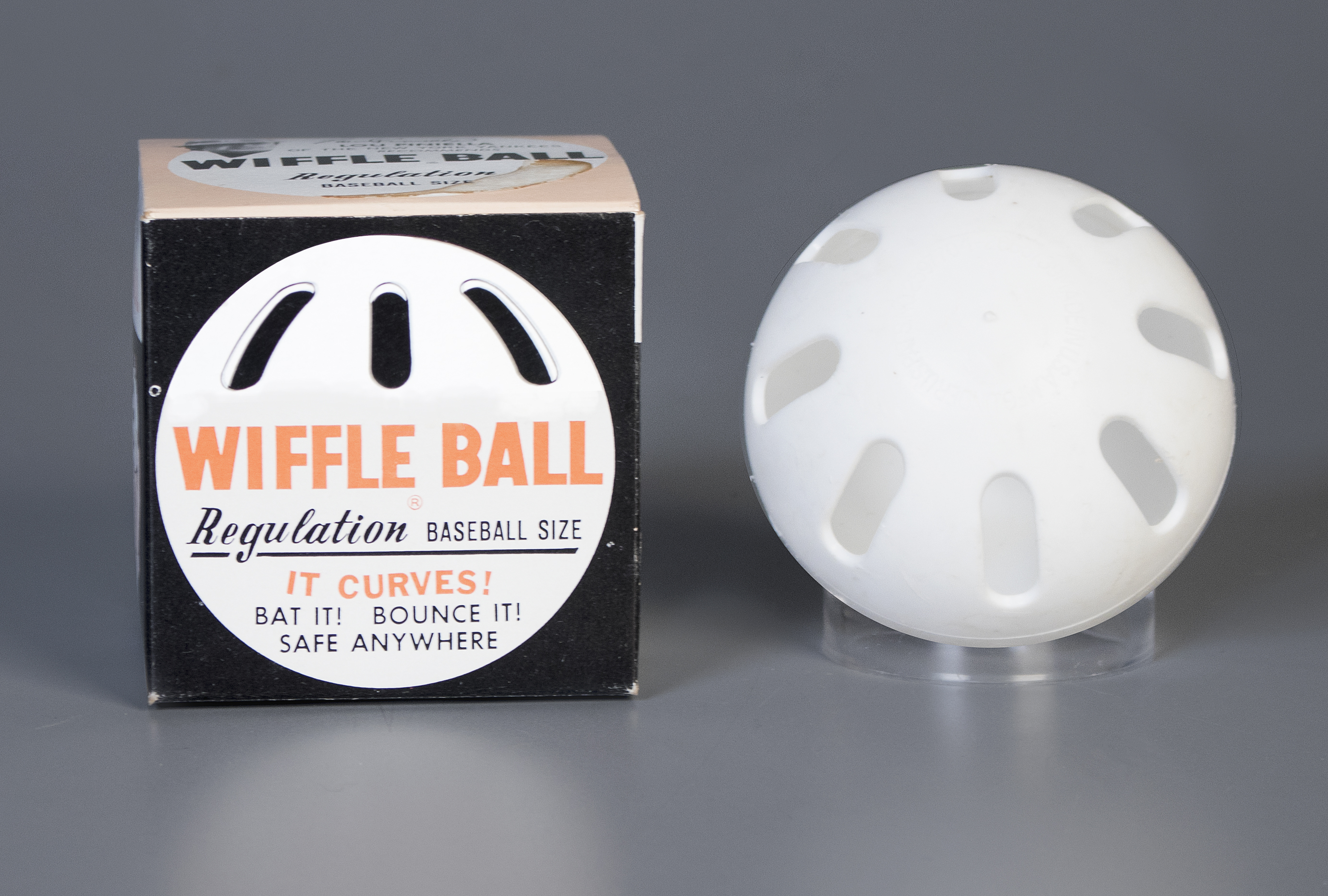 A wiffle ball and a wiffle ball box