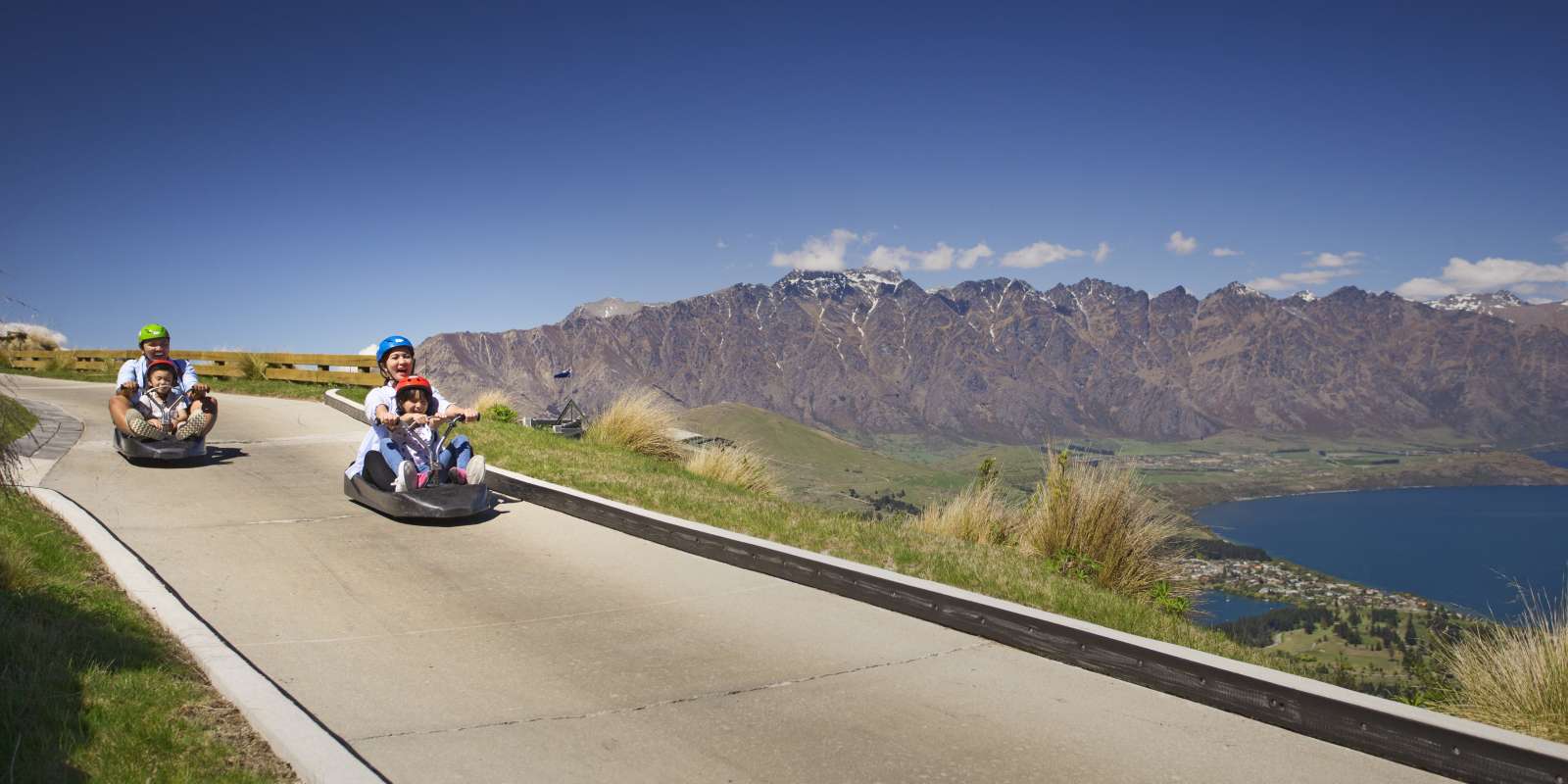 Family on a luge ride at Skyline Goldola Queenstown Family on a luge ride at Skyline Goldola Queenstown