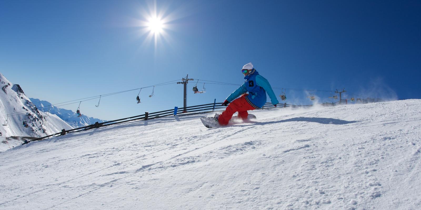 Snowboarder riding at The Remarkables ski field Snowboarder riding at The Remarkables ski field