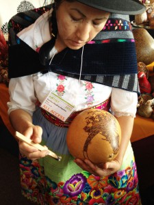 Bertha Aquino works intricate designs onto a gourd at the Santa Fe International Folk Art Market.