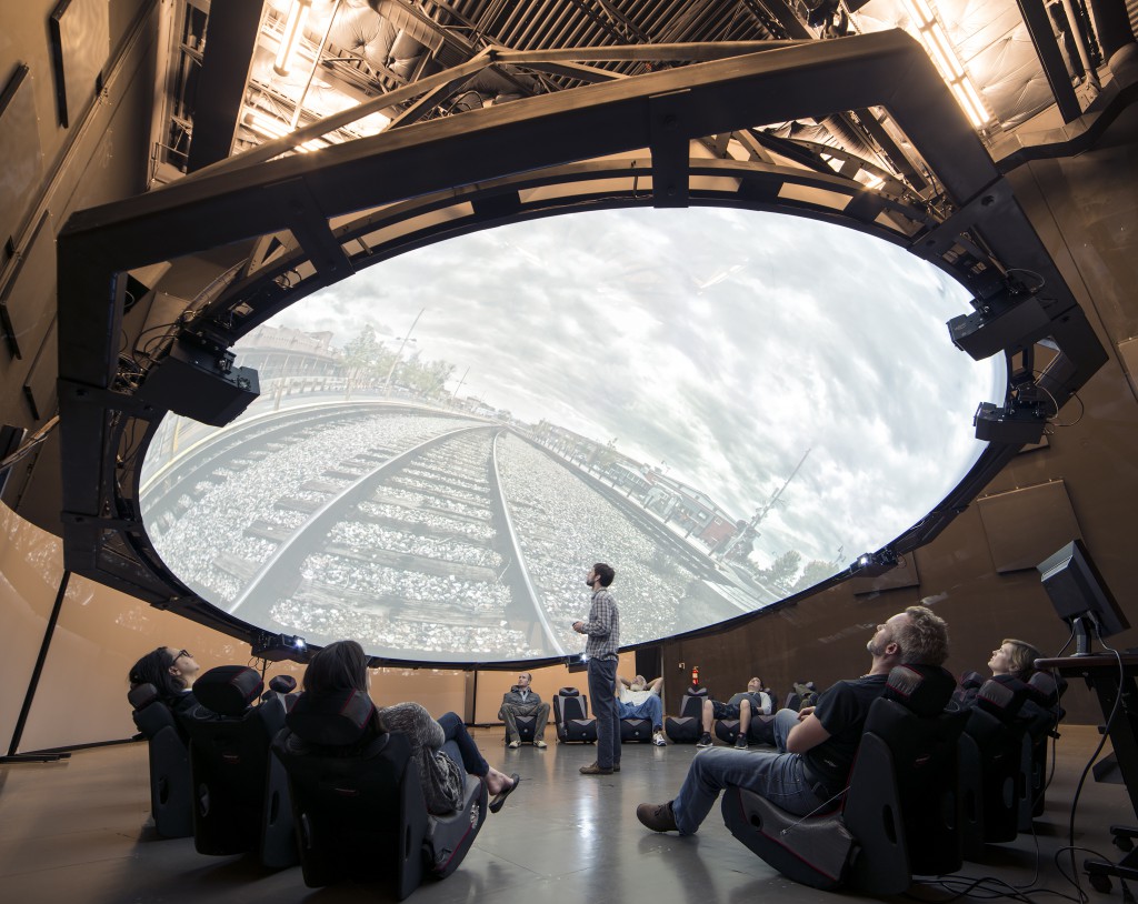 The only dome of its kind in the world, the 8,000 pound structure hangs from the ceiling by a four pulleys which allow the dome to move up and down and rotates from 0° to 90°. And it has 6 projectors, 8 computers, and a 6.1 surround sound.(Photo courtesy of IAIA)