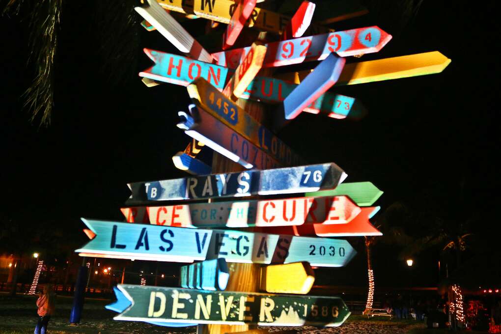 Signs point the way to various near and far destinations from TT's Tiki Bar near the Peace River in downtown Punta Gorda on a Saturday night.  