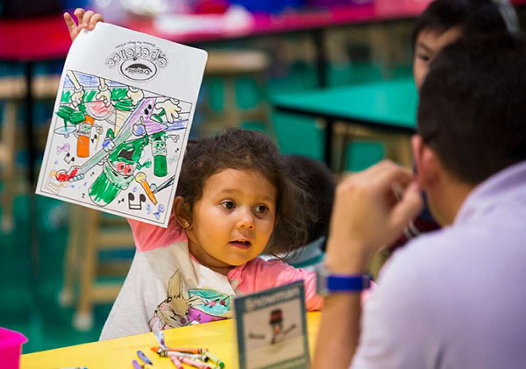 Sarah Chirih, 4, shows her coloring page to her father at the Crayola Experience, one of only two in the world. The other is in Easton, Pa.