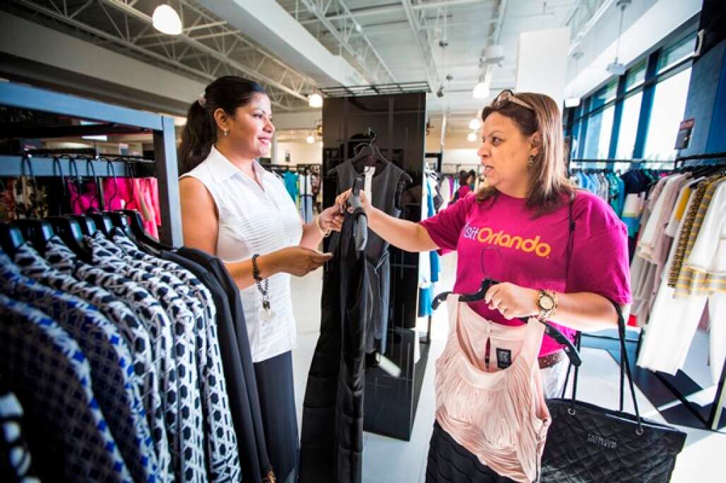 A shopper with a group of Brazilian tour guides and meeting planners is ready to make a purchase while shopping at the new Saks Fifth Avenue Off 5th at the Orlando Premium Outlets on Vineland Avenue in Orlando.