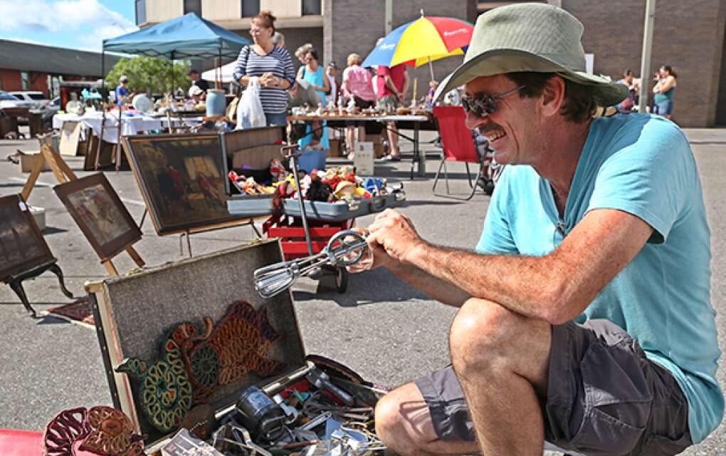 A man checks out an old egg beater in Arcadia's streets.