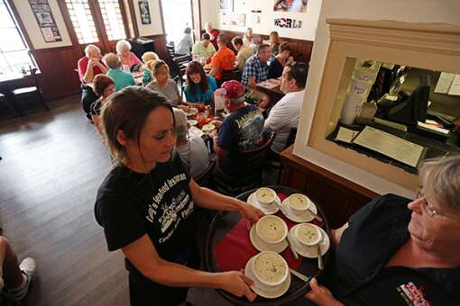 Server Bobbi Newberry, left, and manager Vicki Lowrey deliver cups of the famous clam chowder Tony's Seafood Restaurant. The recipe won a competition in Newport, R.I., three years running and was retired from competition. 