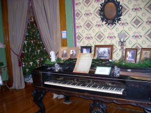 Piano room at Seiberling contains old photos from an earlier era. 