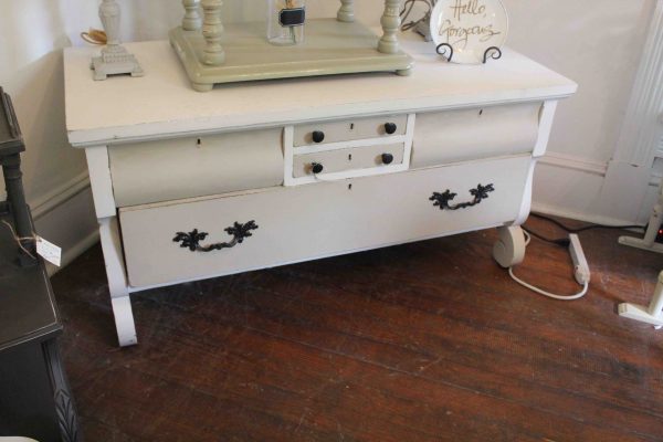 The dresser with small drawers.