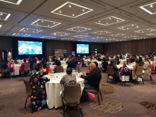 A group of people sitting at tables</p>
<p>Description automatically generated with low confidence