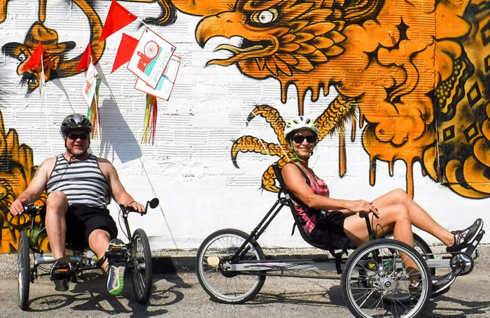Two cyclists in front of Mural