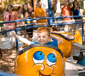 Little boy waving as he rides Bulgy the Goldfish