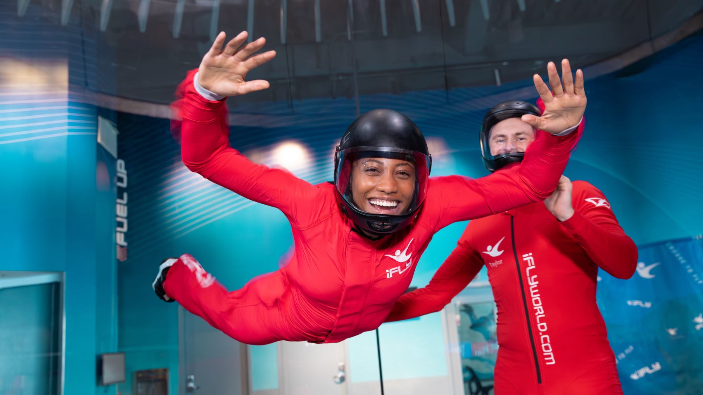 instructor and flyer smile during indoor skydiving flight