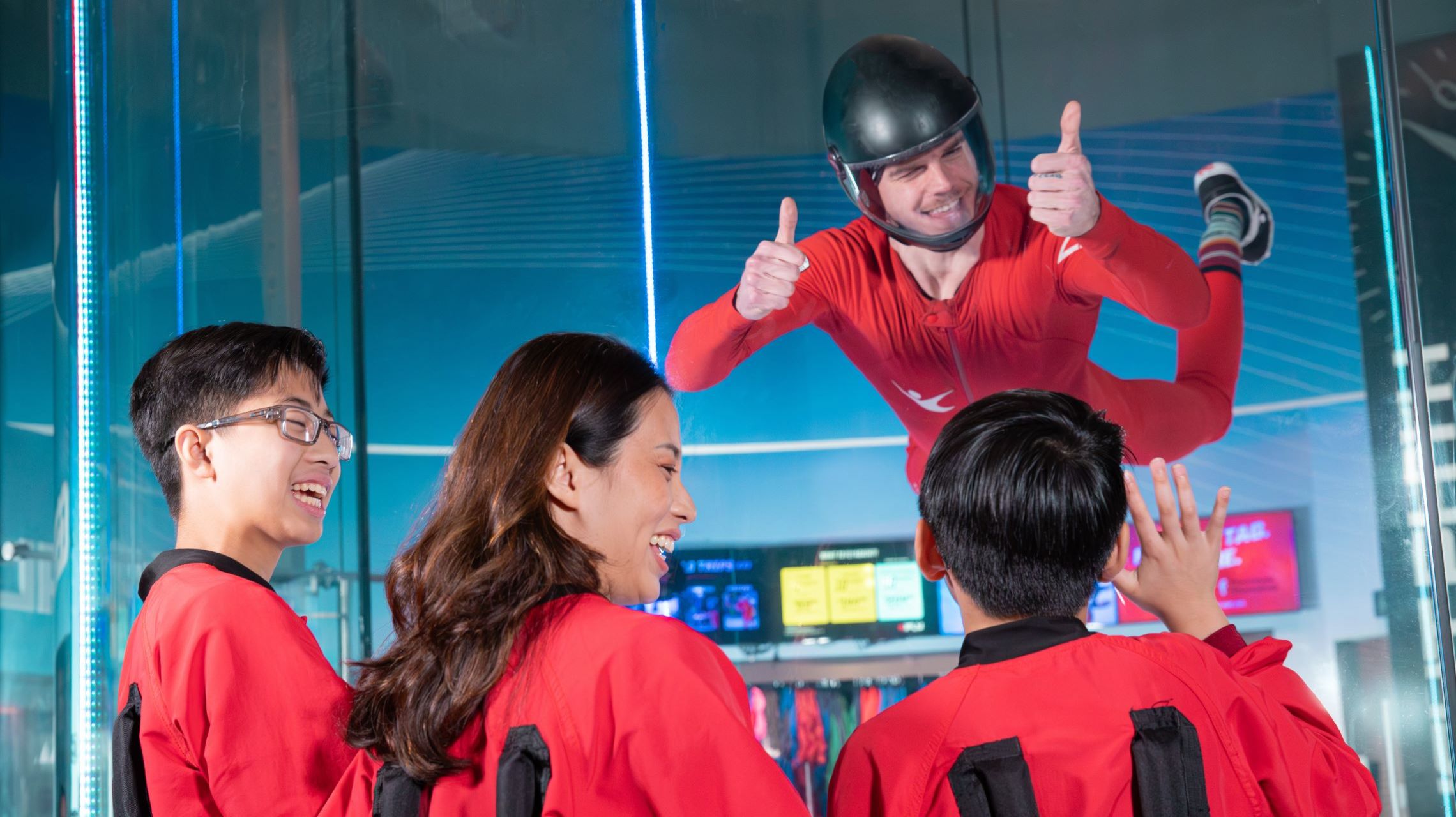 flyer gives thumbs up while indoor skydiving