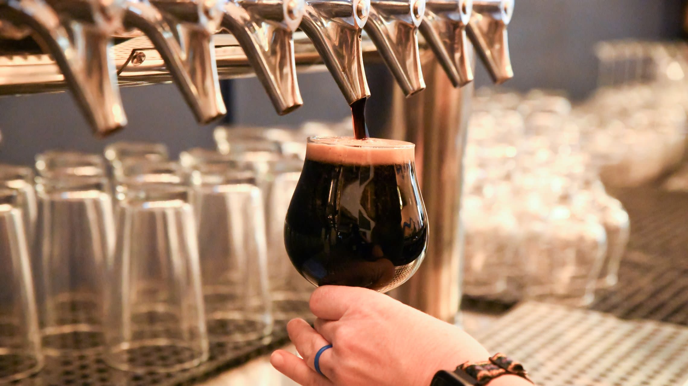 glass of beer beneath tap