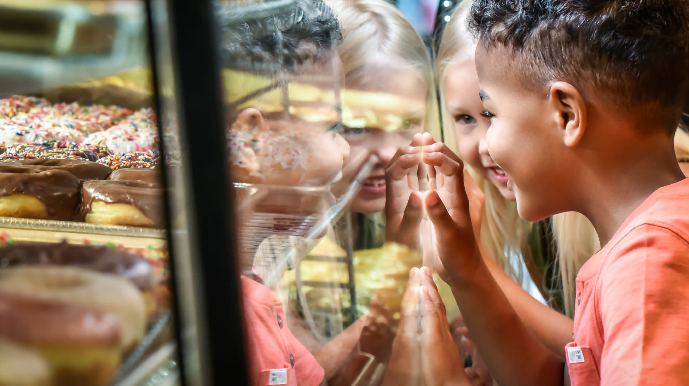 children looking at donuts in case