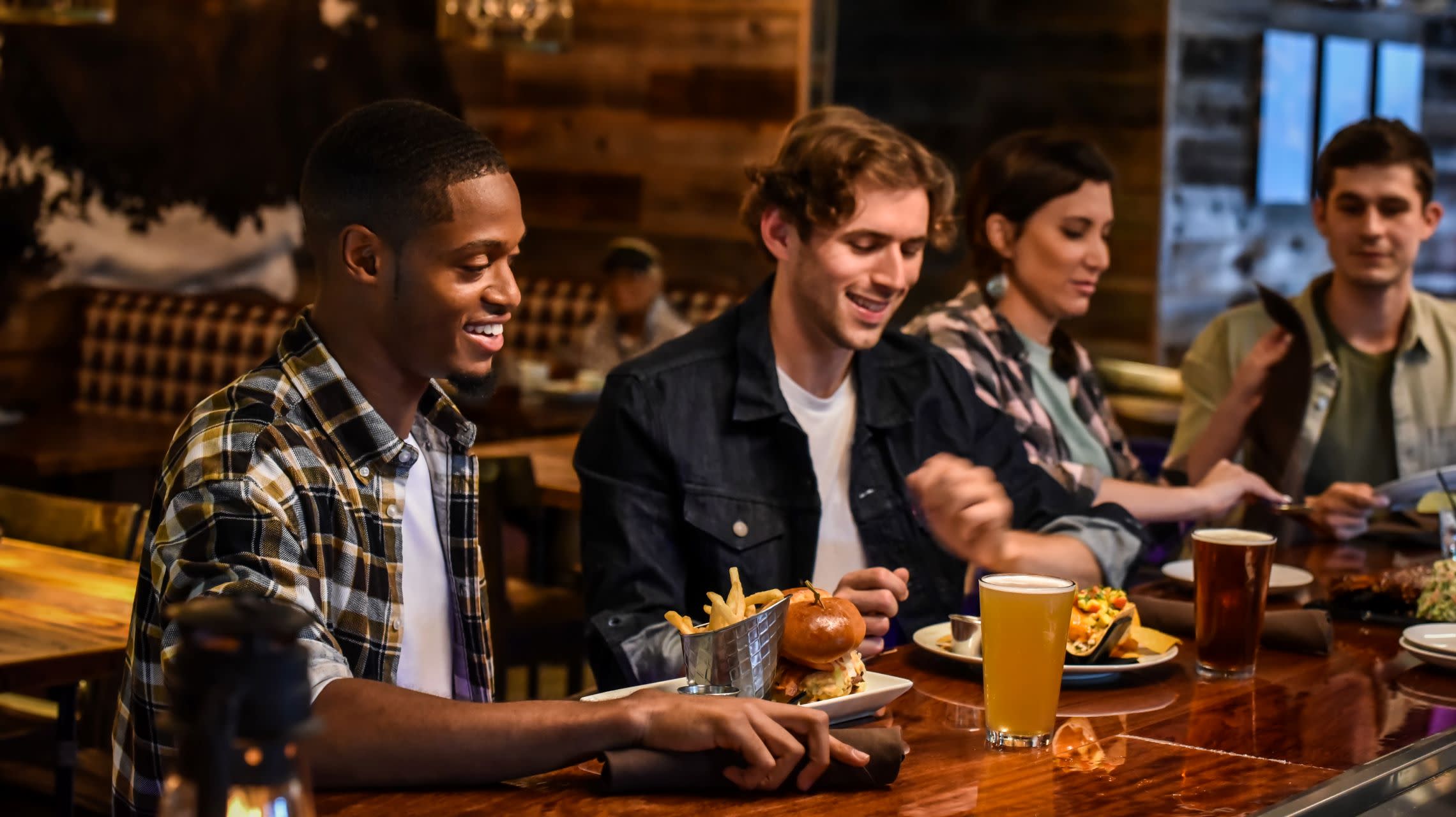 four diners eating at restaurant bar