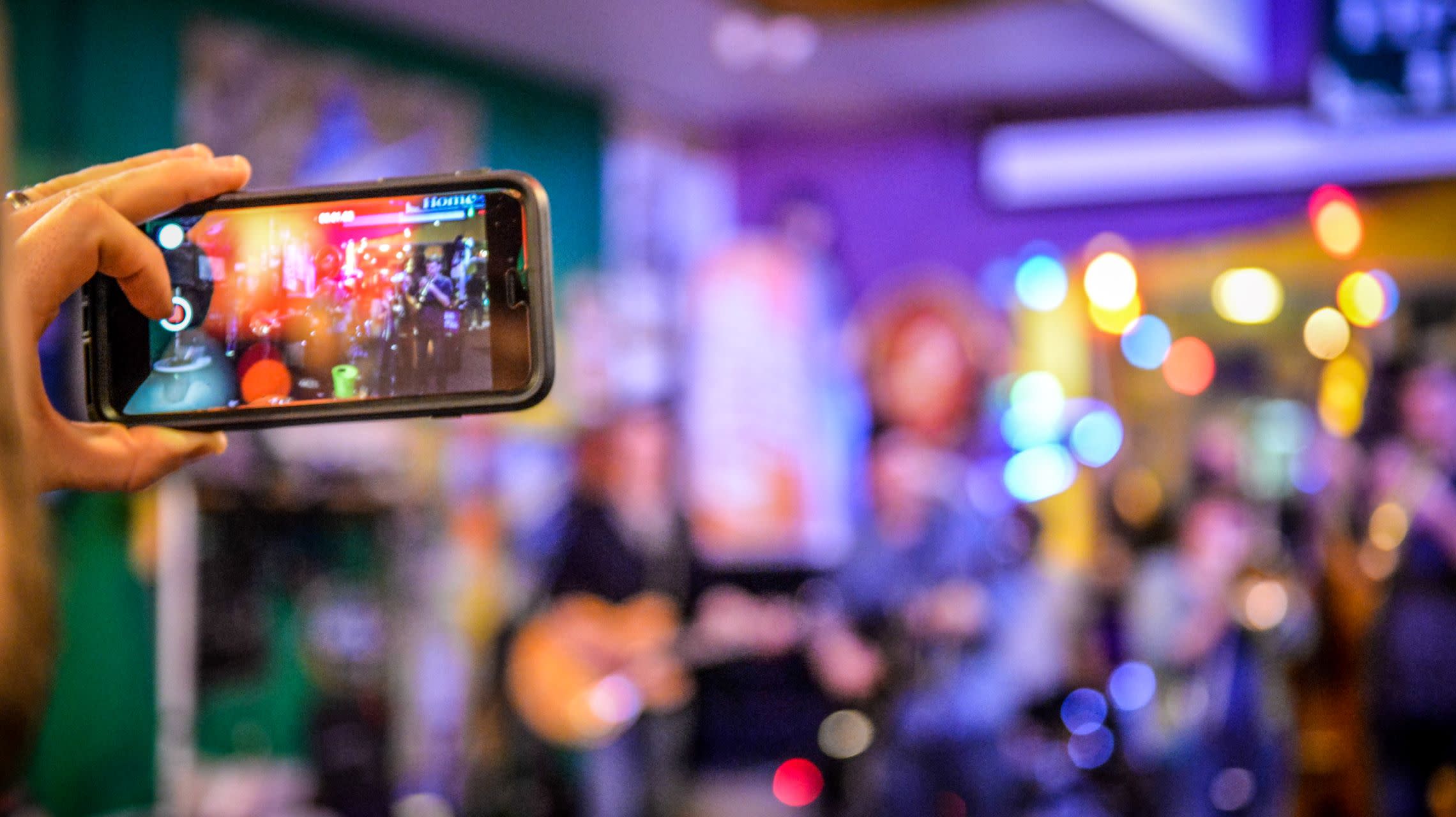 person taking photo of live band