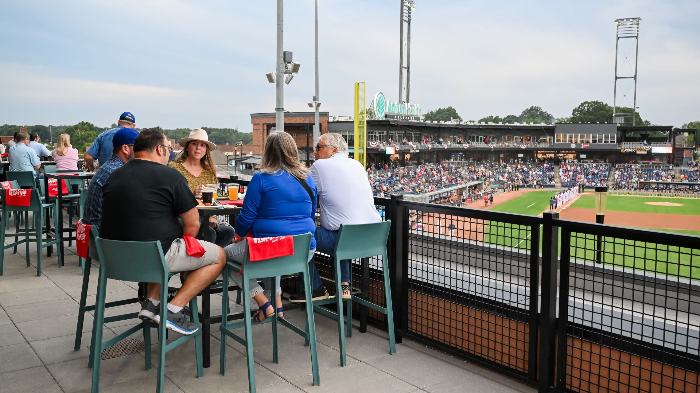 diners sit on patio overlooking ballpark