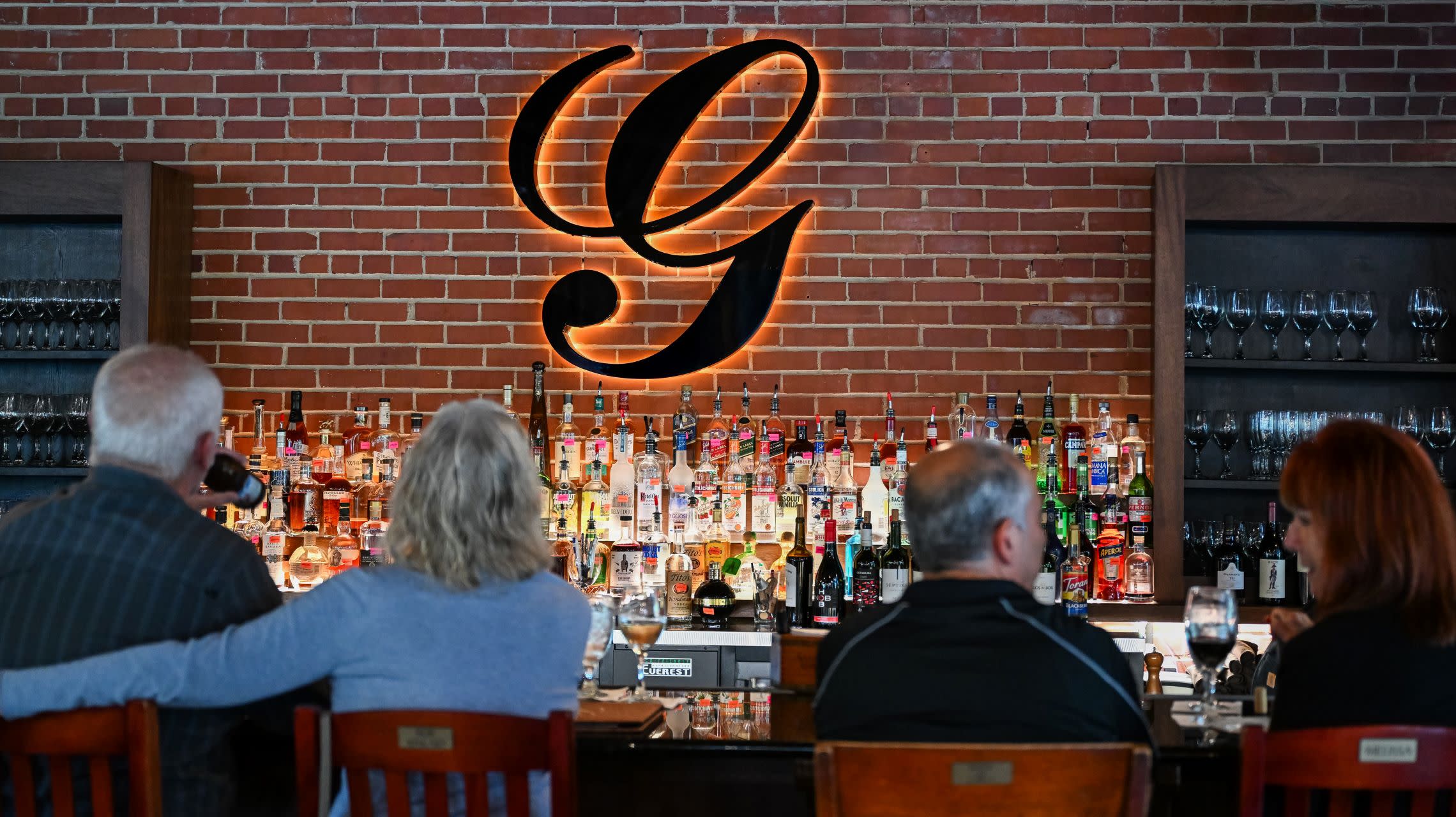 guests sit at restaurant bar