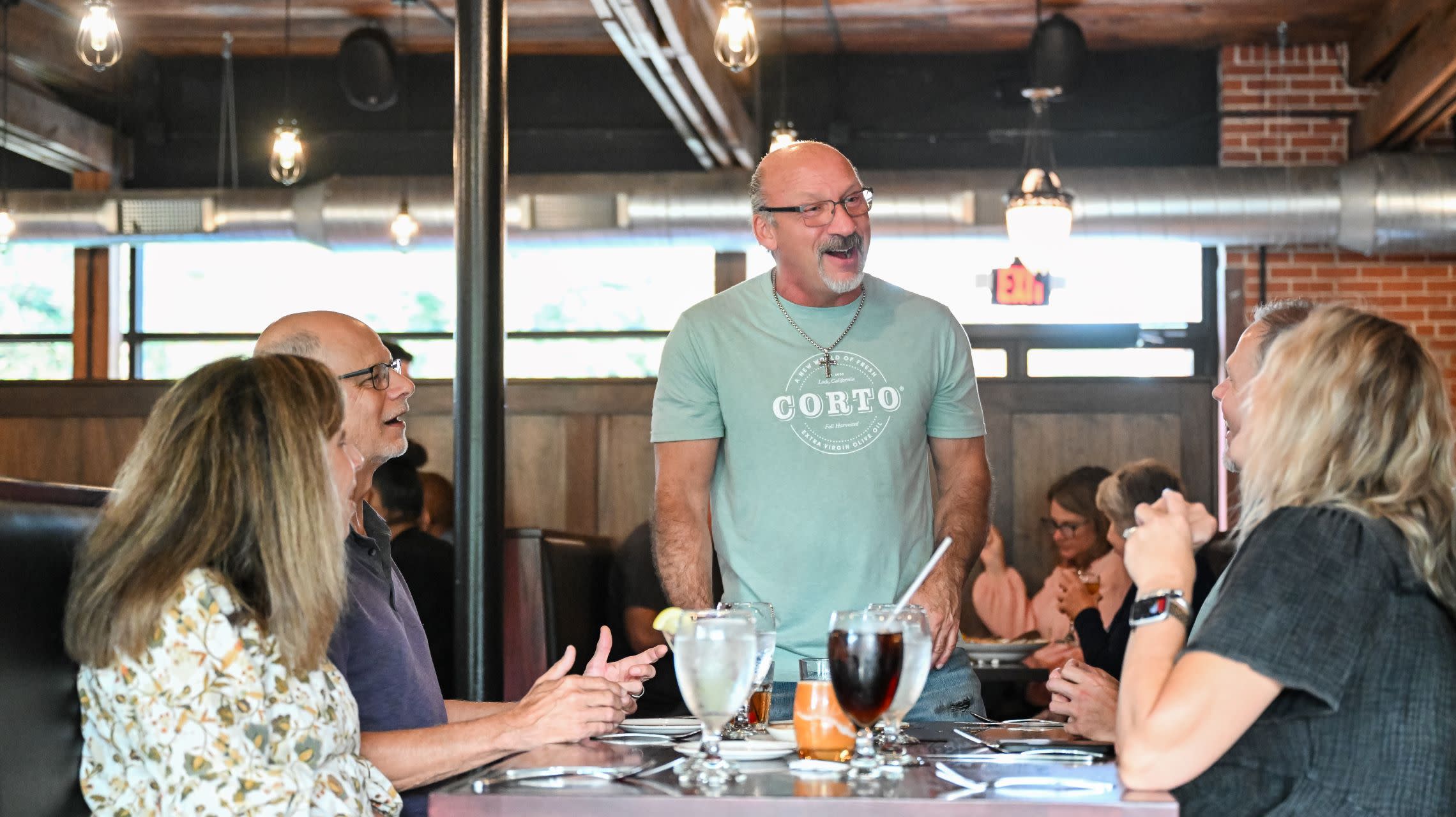restaurant owners greets guests at their table