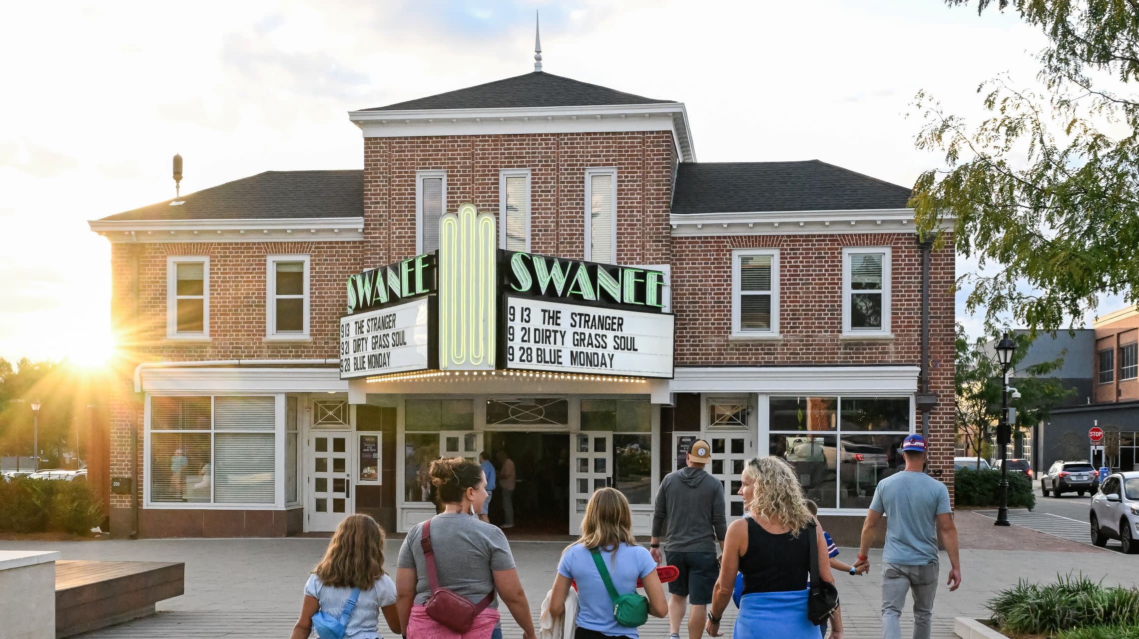 group of people walking to theater entrance