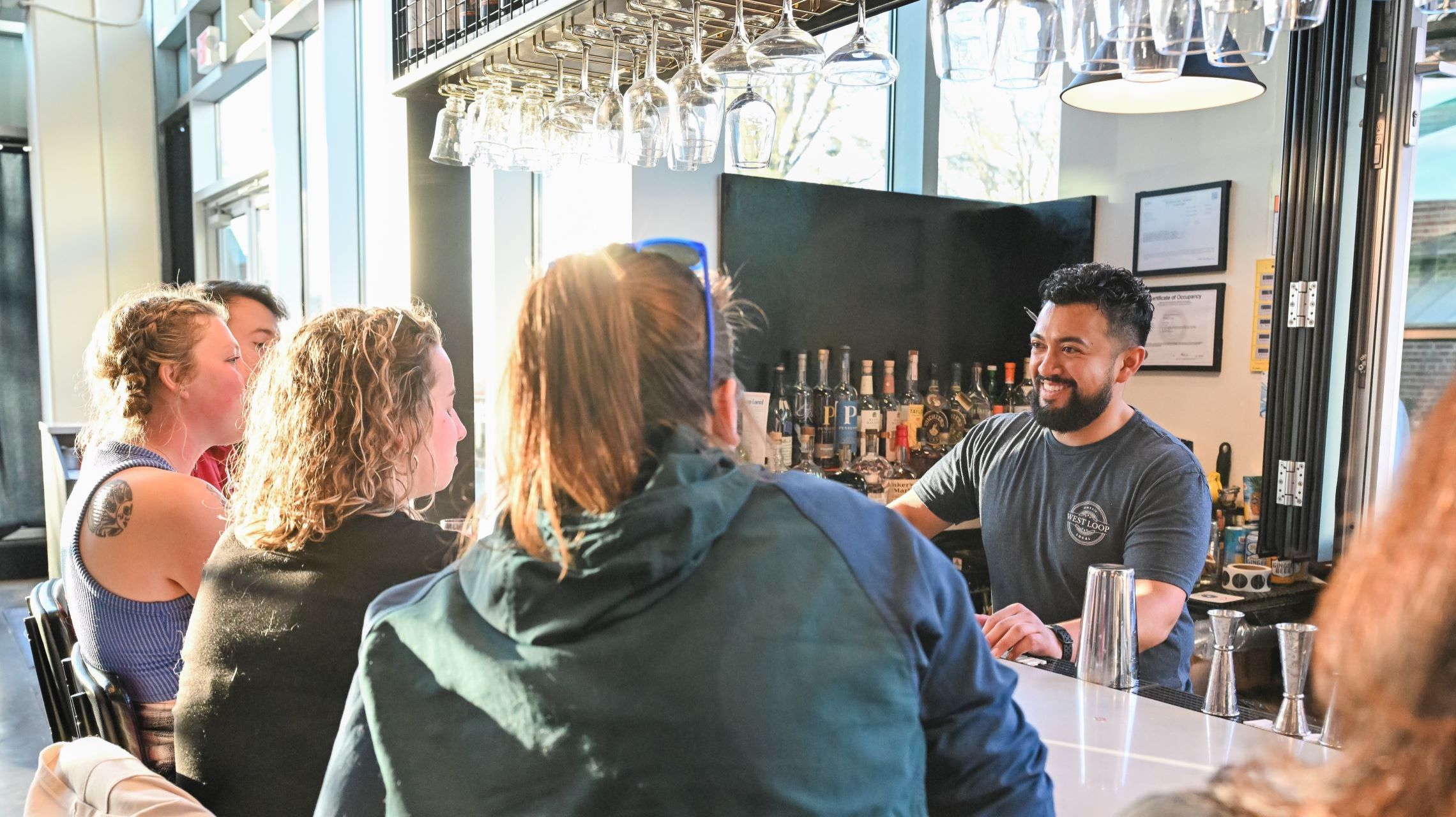 bartender assisting patrons at outdoor bar window