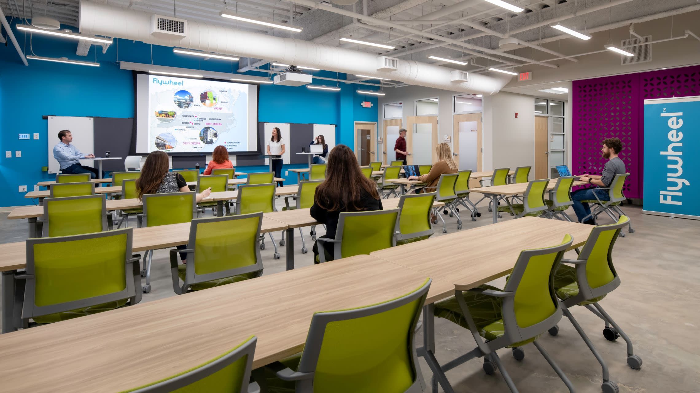 group watching presentation in colorful meeting room