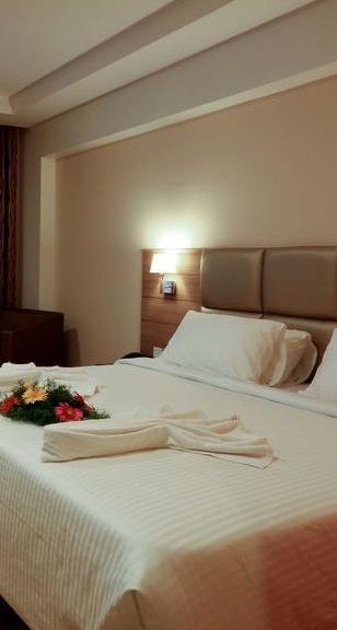 Spacious room with television, bed and table at Fressotel Seetharam, Coimbatore