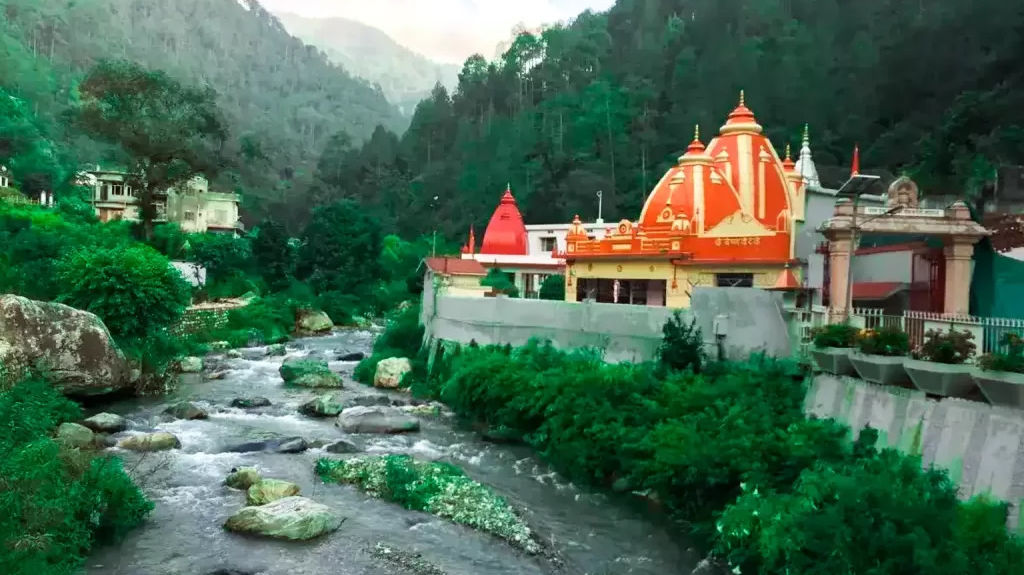 A image of Kainchi dham and a temple beside the flowing river