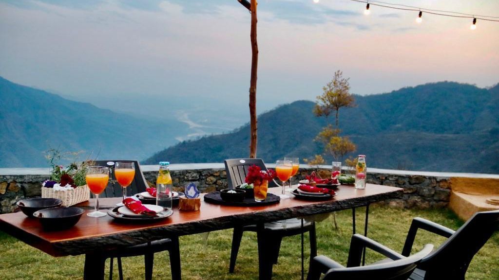 a table with chairs with views of Rishikesh - Kothli Hills