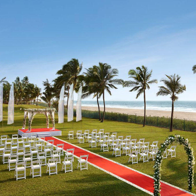 seating arrangements for a Wedding with an arch and red carpet leading to stage - Caravela Beach Resort Goa