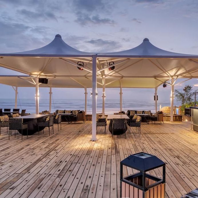 an outside cabana seating arrangement overlooking the beach - Mayfair On Sea, Morjim, Goa