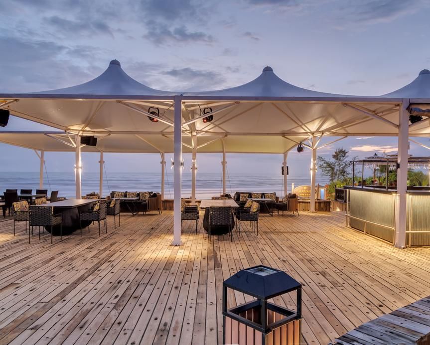 an outside cabana seating arrangement overlooking the beach - Mayfair On Sea, Morjim, Goa