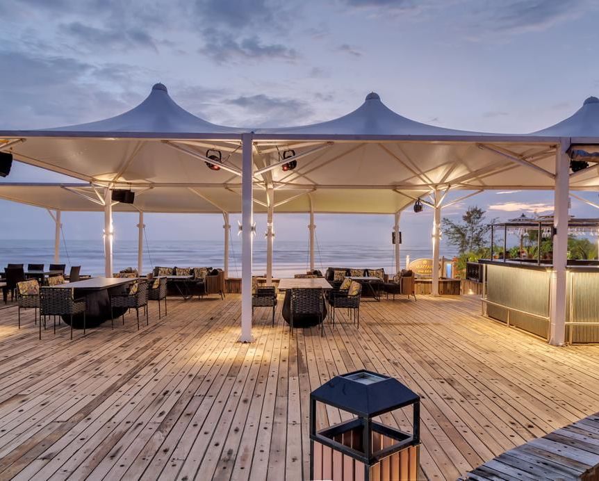 an outside cabana seating arrangement overlooking the beach - Mayfair On Sea, Morjim, Goa