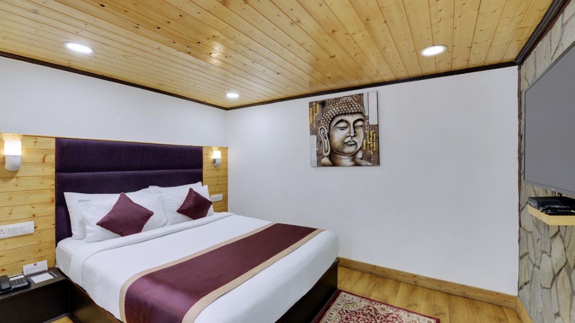 An image of a room with a queen size bed, flat screen TV, decorative lighting - Sumitel Darjeeling