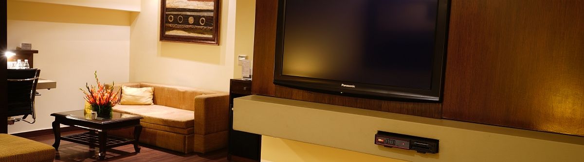 Club Premium Room decked with a television and a sofa at Shervani Nehru Place, New Delhi