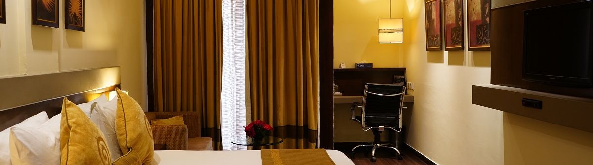 Club Room decked with a comfy bed, a television and a work desk at Shervani Nehru Place, New Delhi