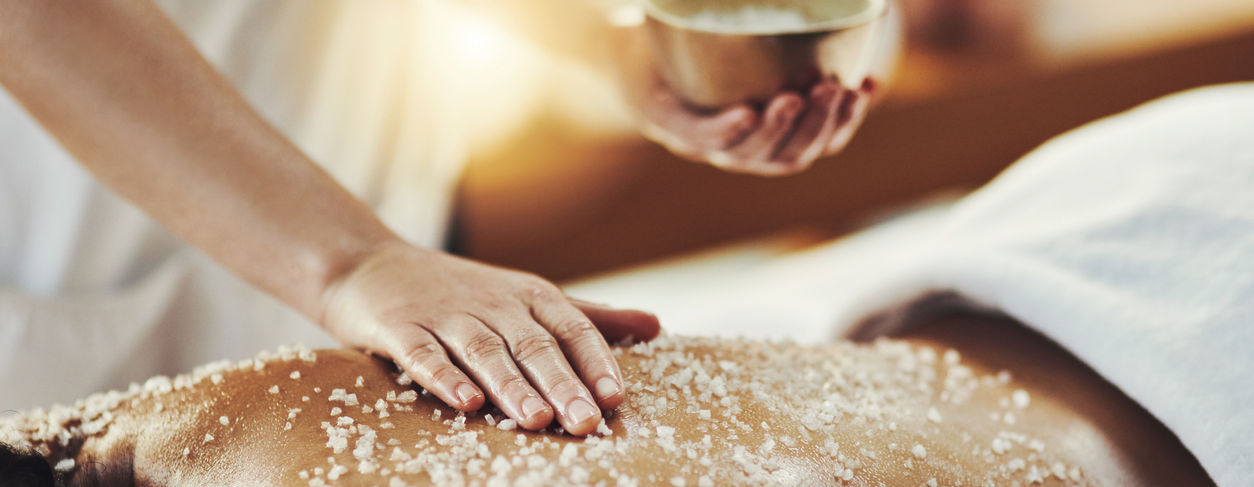 a massage therapist providng a salt therapy massage to a client