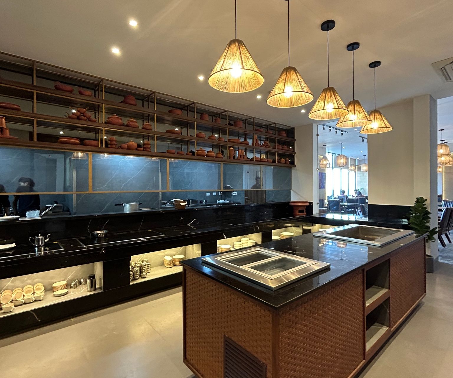 Buffet area in view with chandeliers above a table inside the restaurant - Rhythm Gurugram