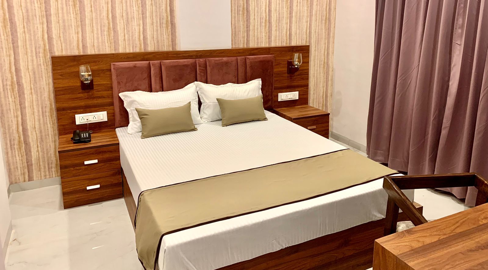 Comfy delux room with a plushy bed and a study table at at Hotel Mumbai House, Indore