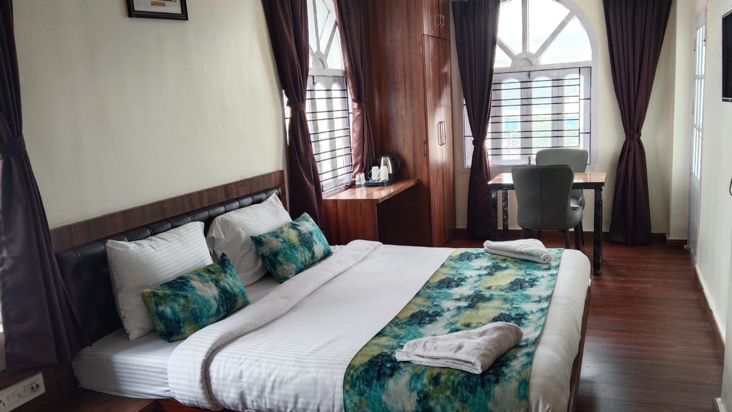 A double bed with towels kept on them inside Premium room with balcony - Ecotel Kolkata