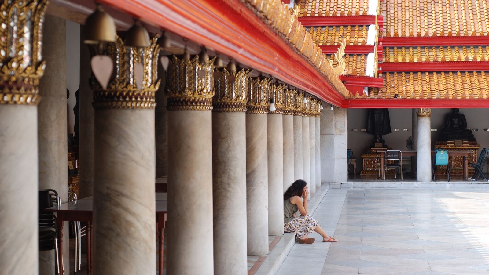 a person sitting at a Buddhist temple during daytime