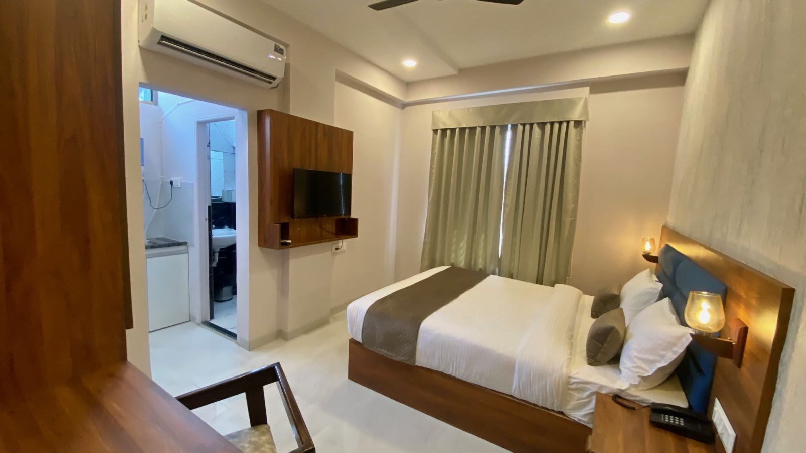 Wide angle view of room with TV and modern amenities  at Hotel Mumbai House, Indore