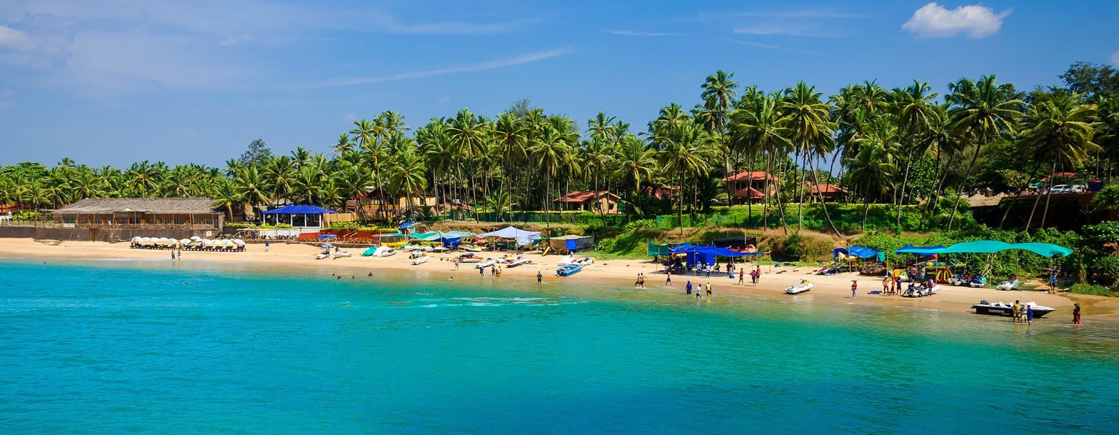 an aerial view of a beach with shacks and people on it