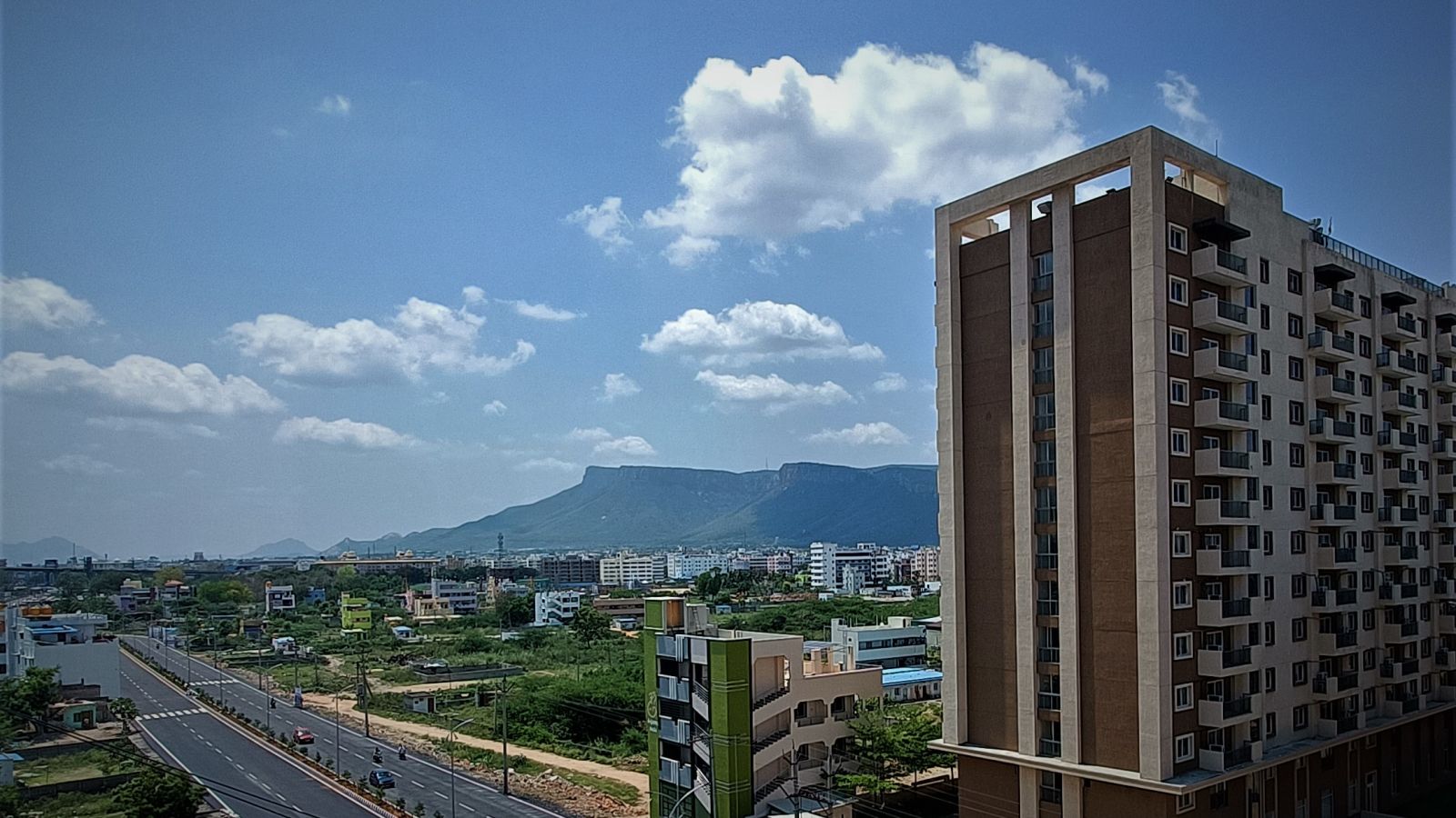 Facade image of Starlit Suites, Tirupati with a mountain in the background