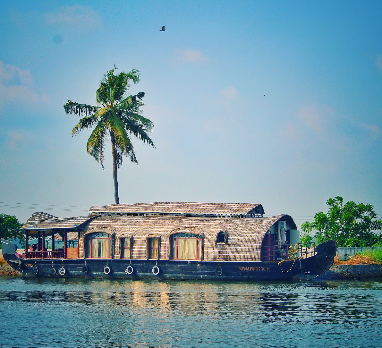 Boat house on a water body with plan tree and greenery in the background