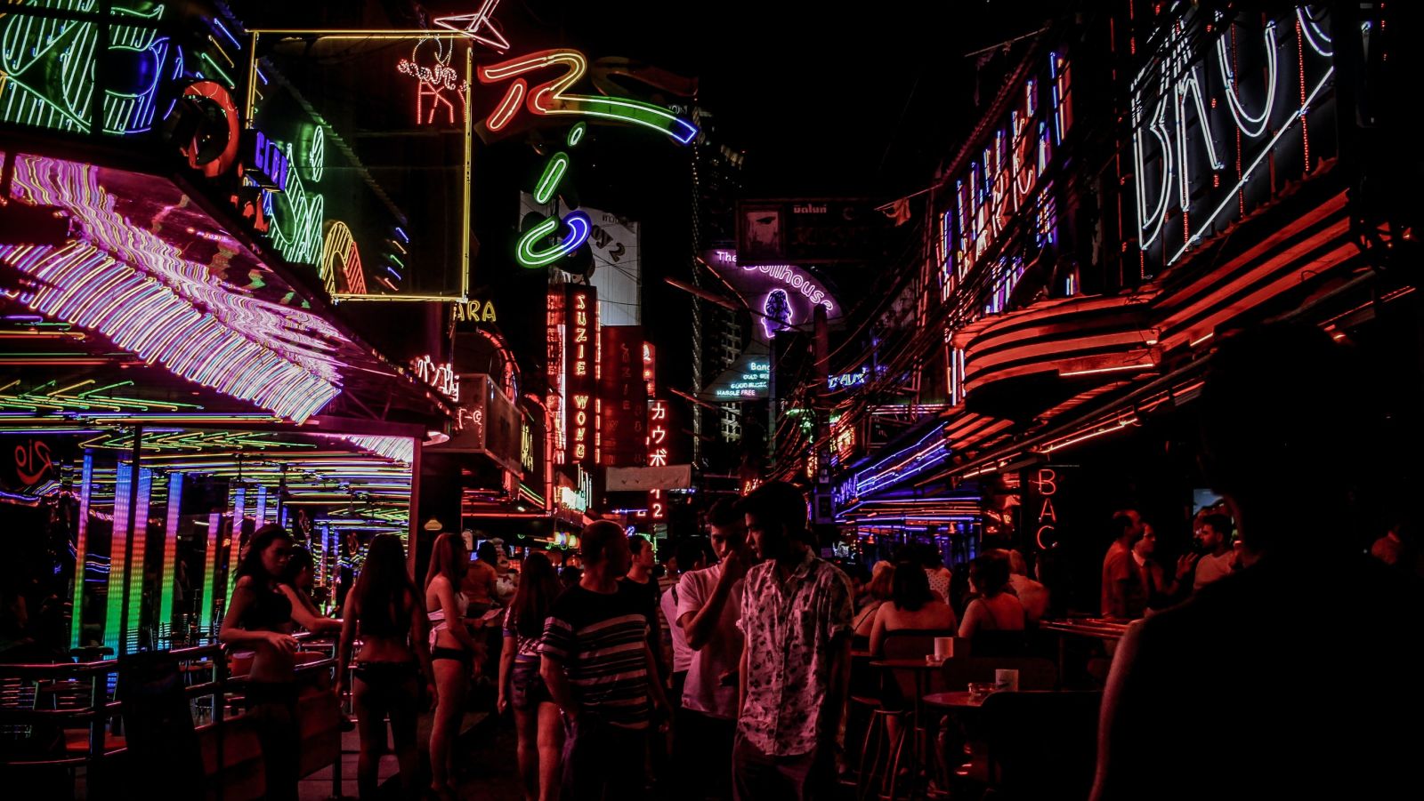 people walking on a street with led lights on buildings