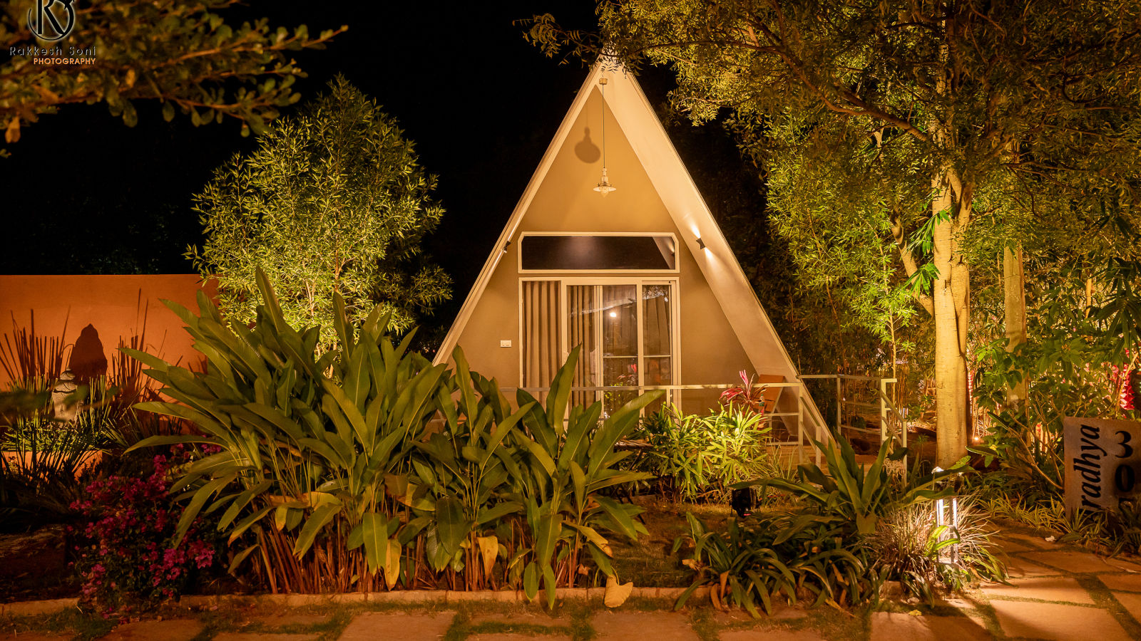 A facade image of the Aradhya cottage with bright lighting and greenery around - Trance Veechika Resort