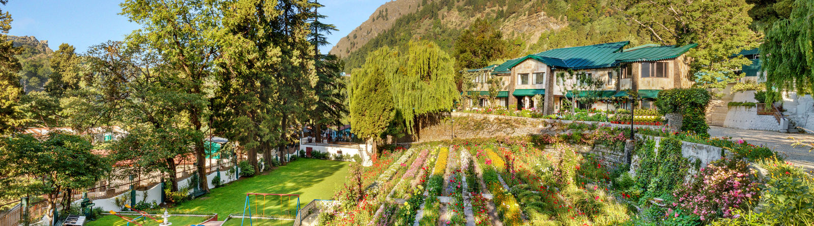   serene lake surrounded by lush green trees and mountains in the background at Shervani Hilltop Nainital 